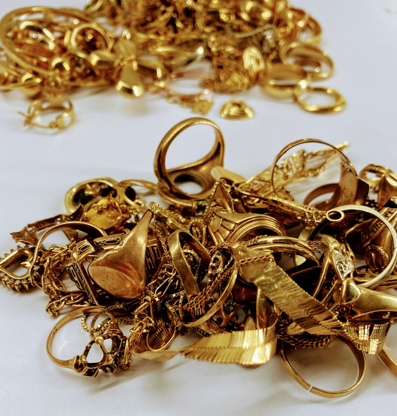 Gold jewelry gathered on a white surface